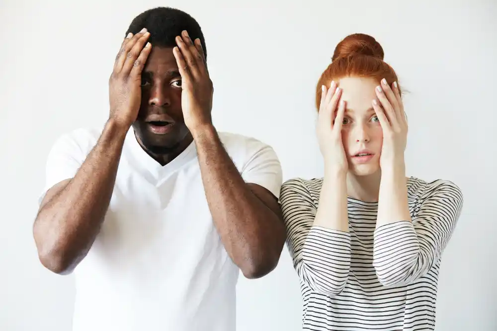 Two people holding their heads with shocked expressions, illustrating the brain’s instinctive reaction to fear- 