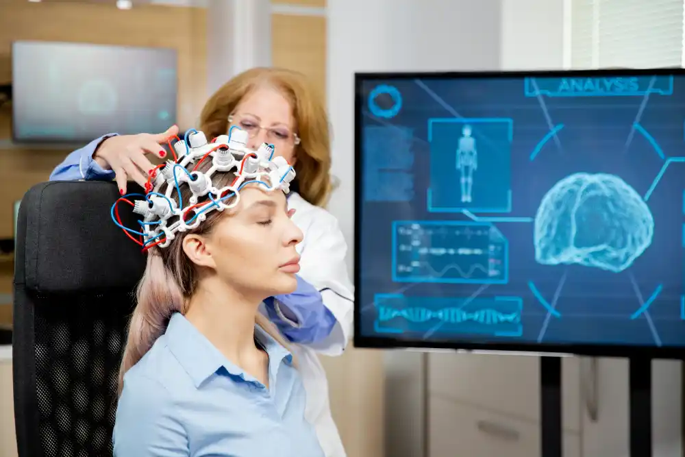 Neuroscientist performing brain scan using neuroplasticity monitoring equipment on a calm female patient, with brain activity data on digital screen - Save your Brain Wellness