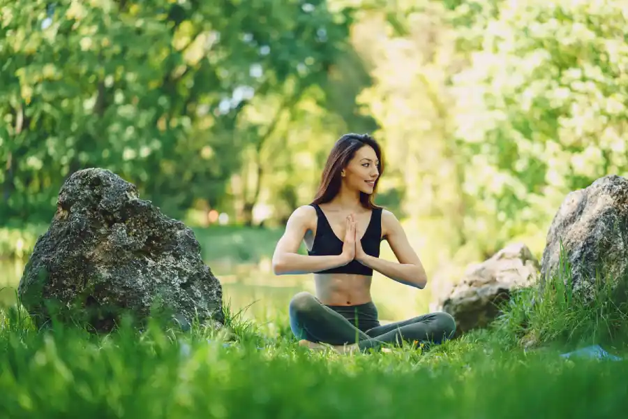 Woman meditating in nature, practicing silence for brain wellness - Save your Brain wellness