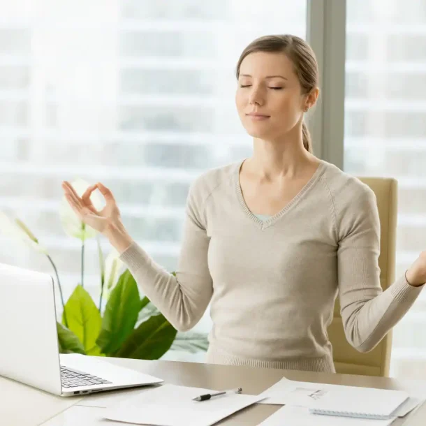 Woman practicing mindfulness meditation at her desk, showing how daily habits like meditation can support brain growth and mental wellness. Save your Brain Wellness