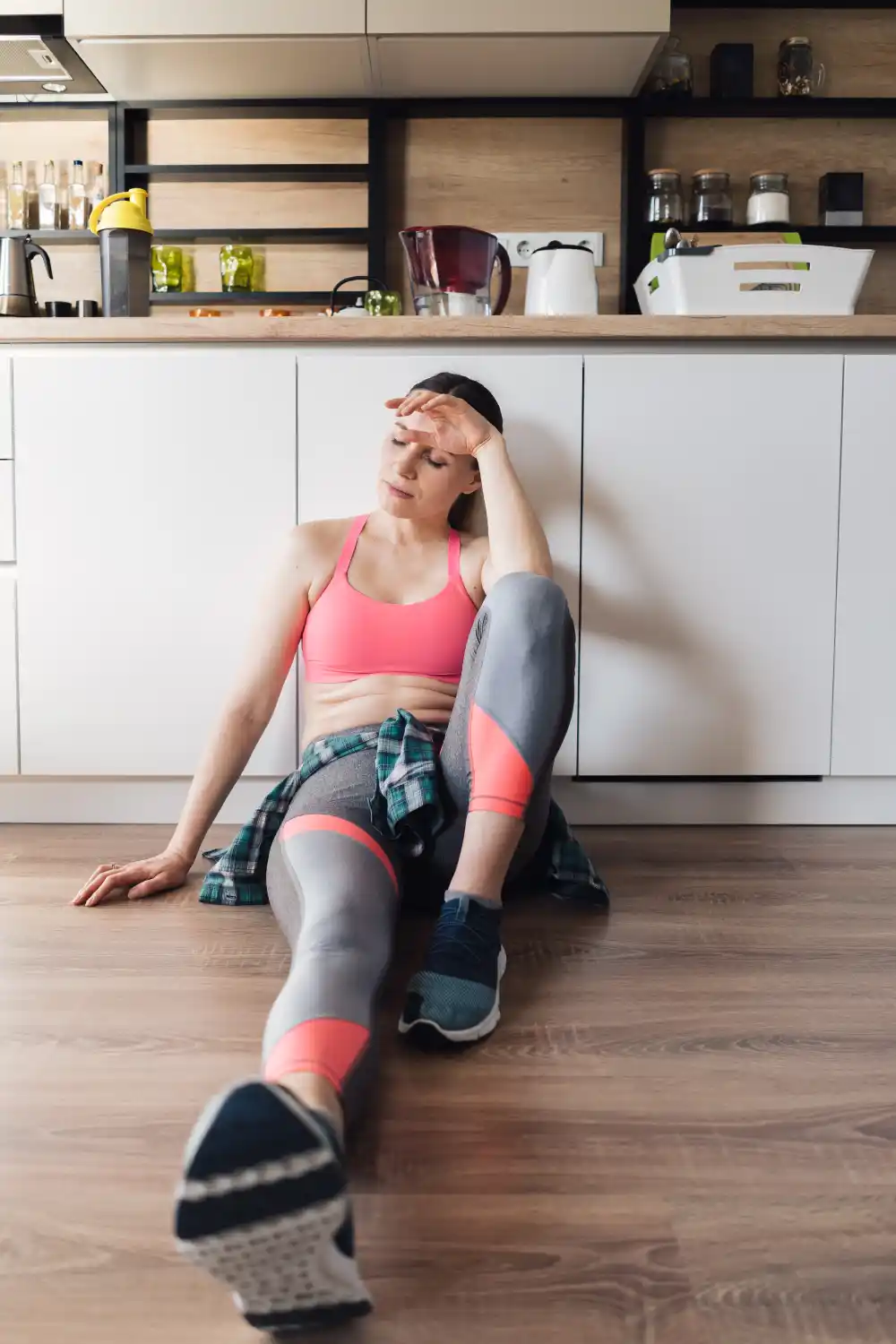 Tired woman stretching before a workout in the morning with low energy due to poor sleep.