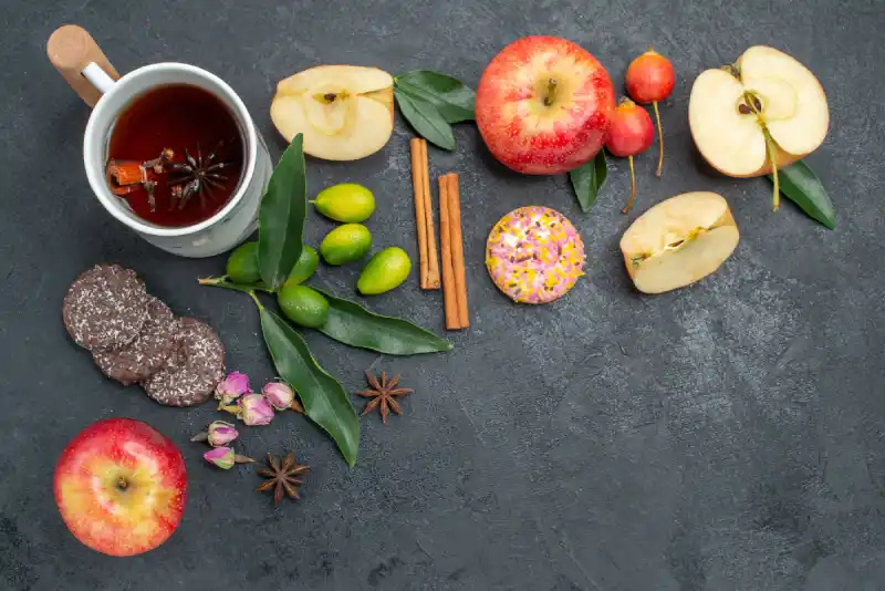 Natural foods that lower blood pressure and boost brain health – dark chocolate, green tea, and apples on a table - Save your Brain Wellness