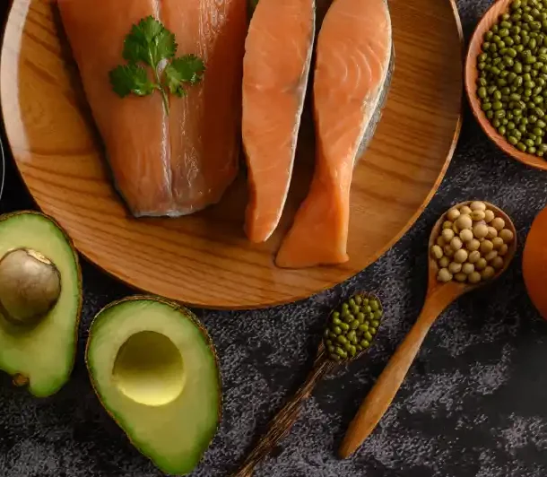 Avocados, salmon, and olive oil on wooden table – healthy fats for brain health