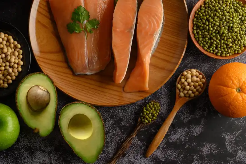 Avocados, salmon, and olive oil on wooden table – healthy fats for brain health