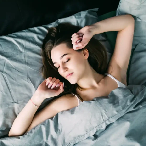 Young woman sleeping peacefully in bed after taking magnesium supplement for better sleep and brain health