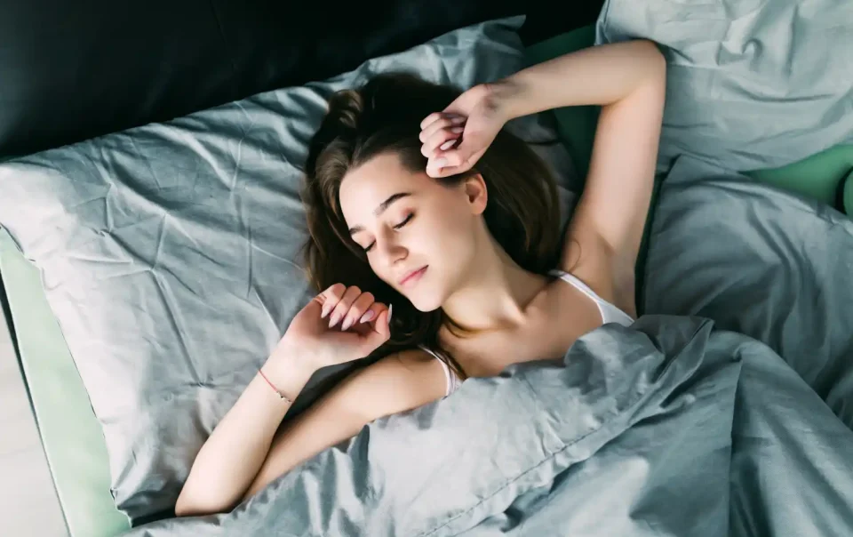 Young woman sleeping peacefully in bed after taking magnesium supplement for better sleep and brain health