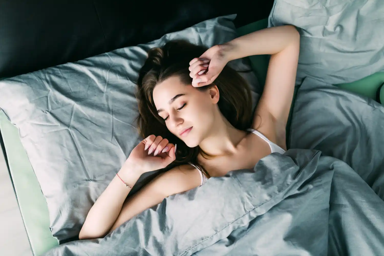 Young woman sleeping peacefully in bed after taking magnesium supplement for better sleep and brain health - Save your Brain Wellness